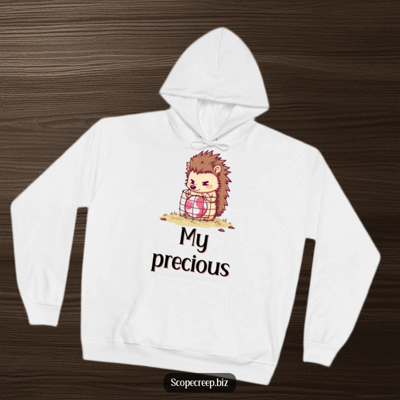 Funny hedgehog character focused on building a tiny cage around a bouncing ball, soft hoodie material, humorous apparel.